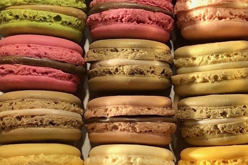Colorful array of authentic French macarons, a treat to enjoy on a food tour in Paris.